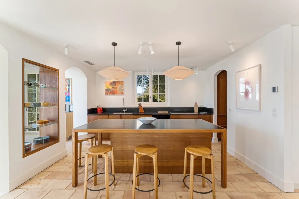 Kitchen with oak island, breakfast bar and black stone worktops